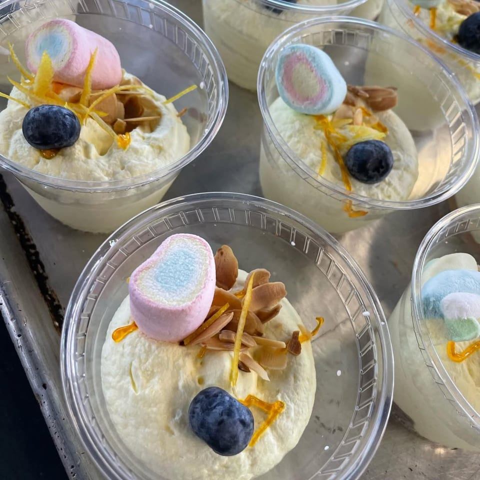 Close-up of Donna Sarah's dessert cups with whipped cream, blueberries, marshmallows, and orange zest.